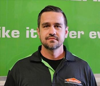 SERVPRO employee in front of green background